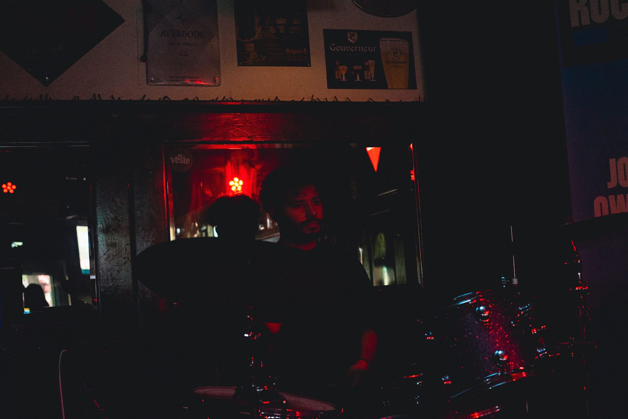 Drummer in rood licht tijdens een optreden